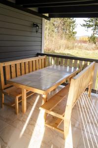 drewniany stół piknikowy i ławka na ganku w obiekcie Ankamy Sweet Home w mieście Worochta
