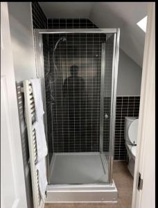 a man standing in a shower in a bathroom at Charming 3-Bed House in Gloucester in Gloucester