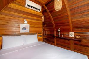 ein Schlafzimmer mit einem Bett in einem Holzzimmer in der Unterkunft Tropical Chalet 2BR Villa Pasak Paradise 1 with Private Pool, Laguna 10 min drive in Ban Pak Lak