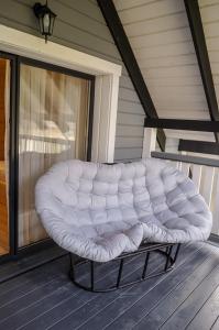 a white tufted bench sitting on a porch at Ankamy Sweet Home in Vorokhta