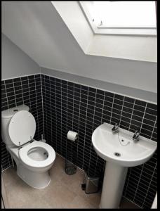 La salle de bains est pourvue de toilettes et d'un lavabo. dans l'établissement Charming 3-Bed House in Gloucester, à Gloucester