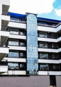 um edifício de apartamentos alto com muitas janelas em The Haven254 em Nakuru