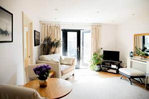 un soggiorno con divano e tavolo di Central Spacious Ground Floor Flat with Courtyard a Kingsbridge