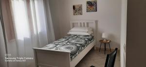 ein kleines Bett in einem Zimmer mit Fenster in der Unterkunft CIVICO 16A - Apartment - with private parking in Quartu SantʼElena