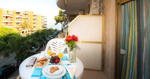 einen Tisch mit Tellern aus Essen auf einem Balkon in der Unterkunft Ona Internacional Apartments in Cambrils