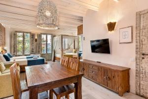 een woonkamer met een eettafel en een tv bij La Bodega Suites in Hospitalet de Llobregat