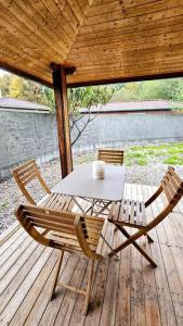 uma mesa e duas cadeiras num deque de madeira em Le Chalet Du Redon em Margencel