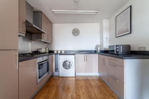 a kitchen with a washer and dryer in it at The Stratford Apartments in London