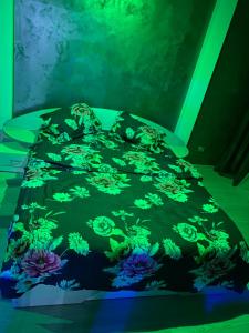 a bed with a black comforter with flowers on it at WRW Center in Bistriţa