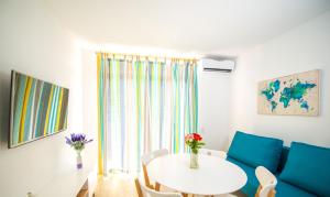 a living room with a white table and blue chairs at Ona Internacional Apartments in Cambrils