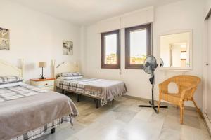 een slaapkamer met 2 bedden, een bureau en een ventilator bij Beautiful 2 bed apartment located at Pueblo Evita in Benalmádena