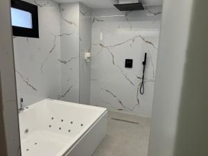 a bathroom with a white tub and a sink at Alojamientos Cervantes in Linares