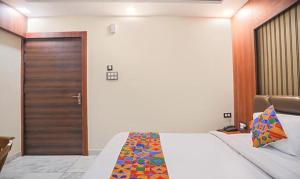 - une chambre avec un lit et une porte en bois dans l'établissement FabHotel The Treenity House, à Allahābād
