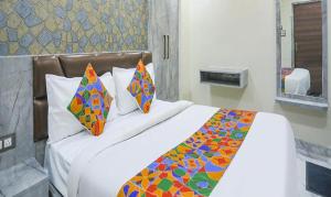 阿拉哈巴德FabHotel The Treenity House的一间卧室配有一张大床,提供色彩缤纷的床单和枕头 更多24张照片