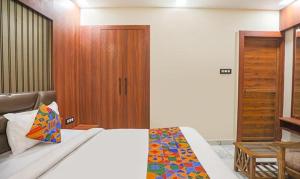 - une chambre avec un lit et une porte en bois dans l'établissement FabHotel The Treenity House, à Allahābād