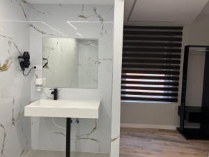 a bathroom with a white sink and a mirror at Alojamientos Cervantes in Linares