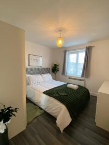 um quarto com uma grande cama branca e uma janela em Cosy Apartment Near Bluewater With Private Parking em Kent
