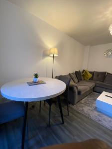 a living room with a table and a couch at Cosy Apartment Near Bluewater With Private Parking in Kent