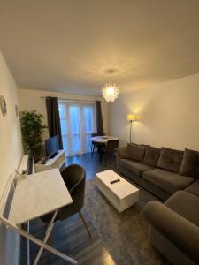 uma sala de estar com um sofá e uma mesa em Cosy Apartment Near Bluewater With Private Parking em Kent