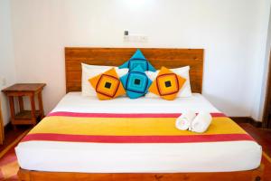 Wild Hut Habarana في هارابانا: غرفة نوم مع سرير مع لحاف ملون