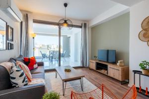 salon z kanapą, telewizorem i stołem w obiekcie Bianca 2-Bedroom Apartment in Larnaca w Larnace