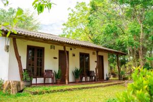 Wild Hut Habarana في هارابانا: منزل مع شرفة وكراسي في الفناء