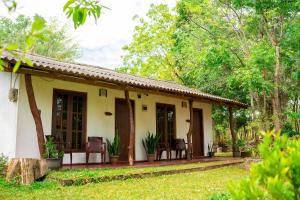 una casa con portico e sedie nel cortile di Wild Hut Habarana a Habarana