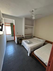 um quarto com 2 camas e uma ventoinha de tecto em Pousada Itaúnas em Conceição da Barra