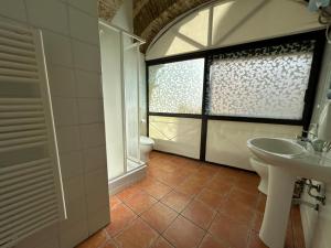 uma casa de banho com um lavatório, um WC e uma janela. em B&B Centro Storico em Caltanissetta
