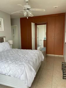 um quarto com uma cama branca e uma ventoinha de tecto em Dawn's Apartment em Margate