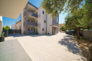 a large white apartment building with a parking lot at Apartment Stefanio in Vodice