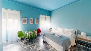 una camera blu con un letto e un tavolo con sedie di GUEST HOUSE SONNINO 37 a Cagliari