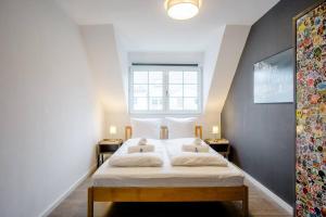 een slaapkamer met een bed met witte lakens en een raam bij Modernes Apartment in Potsdam-Golm - 2 Zimmer - Balkon - Beamer - Disney Plus in Potsdam