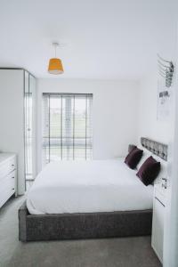 een witte slaapkamer met een groot bed en een raam bij Deluxe 2 Bed Flat in Patchway near Aztec West and Cribbs Causeway Bristol in Bristol