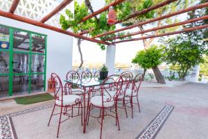 - une table et des chaises rouges sur la terrasse dans l'établissement Villas en Toledo, à Villaluenga