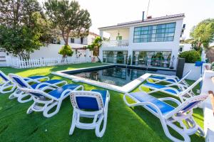 eine Gruppe von Stühlen auf dem Rasen neben einem Pool in der Unterkunft Villas en Toledo in Villaluenga