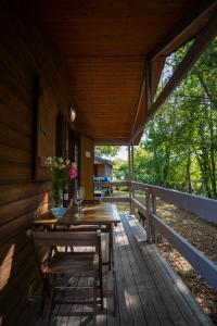 Camping Beau Rivage في Navarrenx: شرفة خشبية عليها طاولة وكراسي
