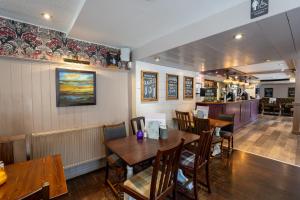 comedor con mesas y sillas de madera en West Port Hotel en Linlithgow