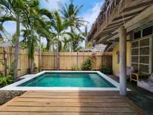 a swimming pool in a backyard with a wooden fence at Villa Bamboo in Gili Trawangan