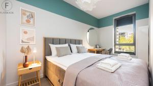 a bedroom with a large bed and a window at Flatbook - City Center Apartments Scala Moderna in Gdańsk