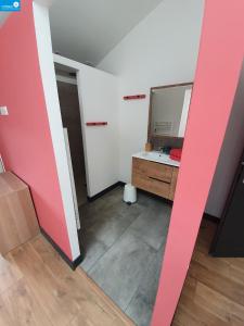 ein Bad mit einem Waschbecken und einem Spiegel im Zimmer in der Unterkunft Romanélou in Balazuc