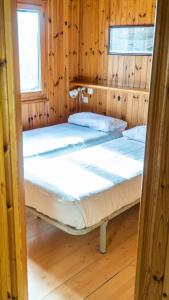 a bedroom with two beds in a wooden room at Camping Playa Las Dunas in El Puerto de Santa María