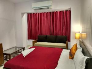 1 dormitorio con 1 cama grande y cortina roja en Cochin Hotel Inn, en Ernakulam