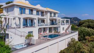 a large white building with a swimming pool at LIVINGHOME SUITES in Parga