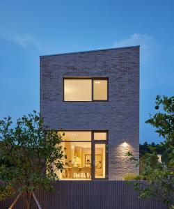 a black brick house with large windows at Gonggan7 in Jeju