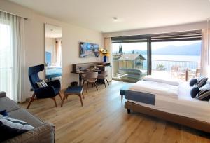 a bedroom with a bed and a desk and a balcony at Villa Remo by Hotel Galvani in Torri del Benaco