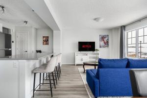 sala de estar con sofá azul y bar en New Cozy Family Townhome Sleeps 10 Comfortably w Banff Pass, en Airdrie