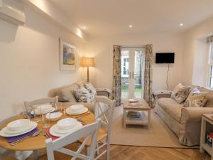 a living room with a table and a couch at Quay Cottage in Salcombe