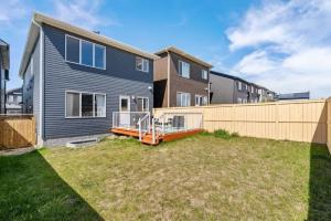 a house with a wooden fence in a yard at Top Rated Luxury House with Central AC, Double Garage Parking, 2 Kitchens, 5 Bedrooms & More! in Balzac