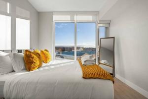 1 dormitorio con 1 cama grande y ventana grande en Downtown Luxurious Apartment with Parking and Gym en Calgary